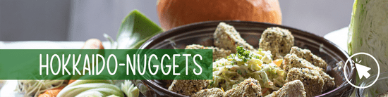 KI generiert: Das Bild zeigt eine Schüssel mit Hokkaido-Nuggets, umgeben von frischem Gemüse. Der Text "HOKKAIDO-NUGGETS" ist prominent darauf abgebildet.