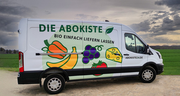 KI generiert: Ein Lieferwagen mit der Aufschrift "DIE ABOKISTE - BIO EINFACH LIEFERN LASSEN", dekoriert mit Obst- und Gemüsebildern.