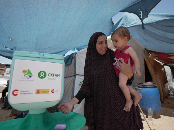 Duaa Abu Sabha nutzt die Handwaschstation, die Oxfam als Hilfsmaßnahme für die Menschen in der Region Al-Mawasi im Gouvernement Khan Yunis bereitgestellt hat