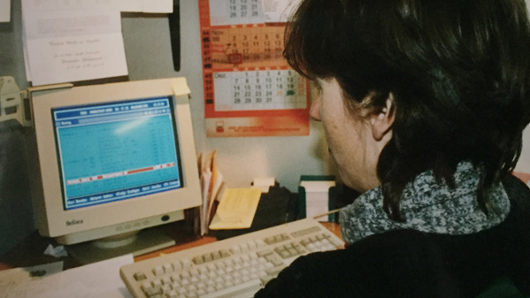 KI generiert: Eine Person sitzt vor einem alten Computerbildschirm im Büro.