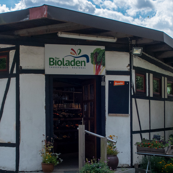 KI generiert: Eingang zu einem Bioladen, beschildert mit "Der Bioladen" und "Demeter".