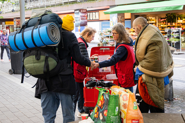 bodo-Mitarbeiterinnen verteilen belegte Brote und heiße Getränke