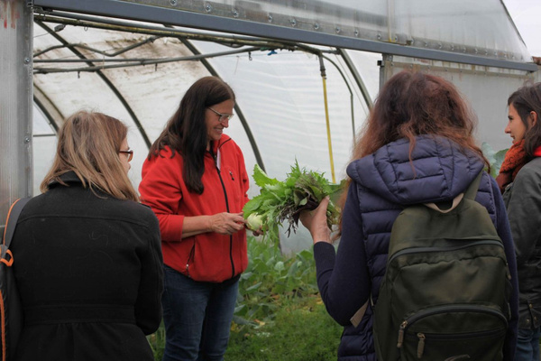 Besucher lassen sich von Gärtnerin die Gärtnerei zeigen